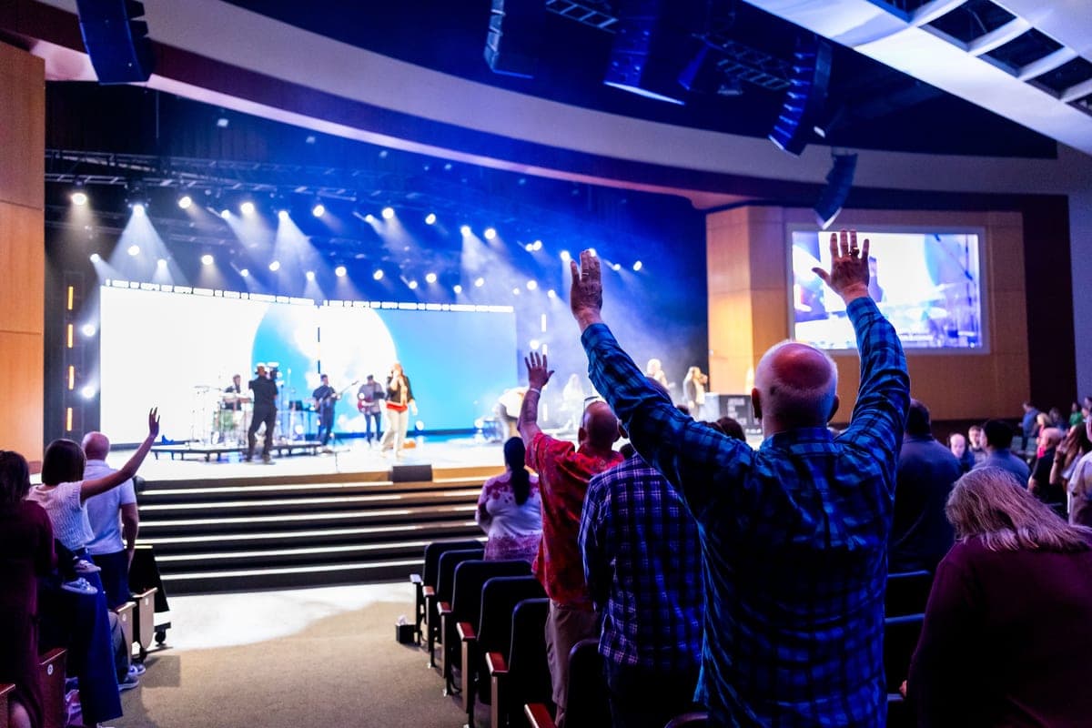 Congregation facing a band on a church stage during a service